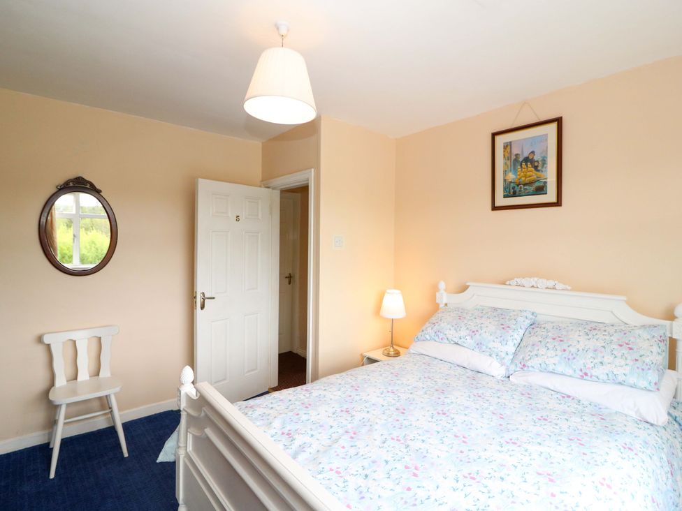 A bedroom with a bed and chair at Forest View in Ballinskelligs, County Kerry