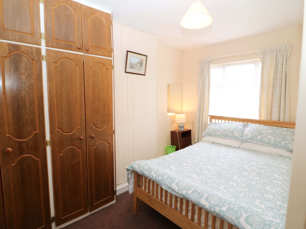 A bedroom with a bed and wardrobe at Forest View in Ballinskelligs, County Kerry