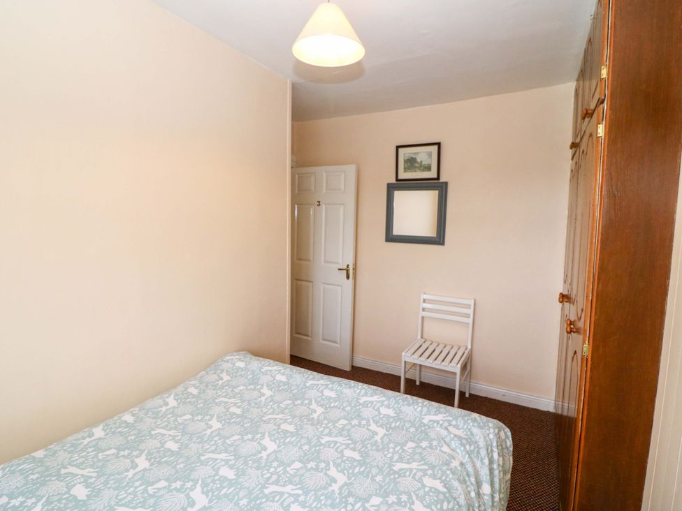 A bedroom with a bed and a chair at Forest View, Ballinskelligs, County Kerry