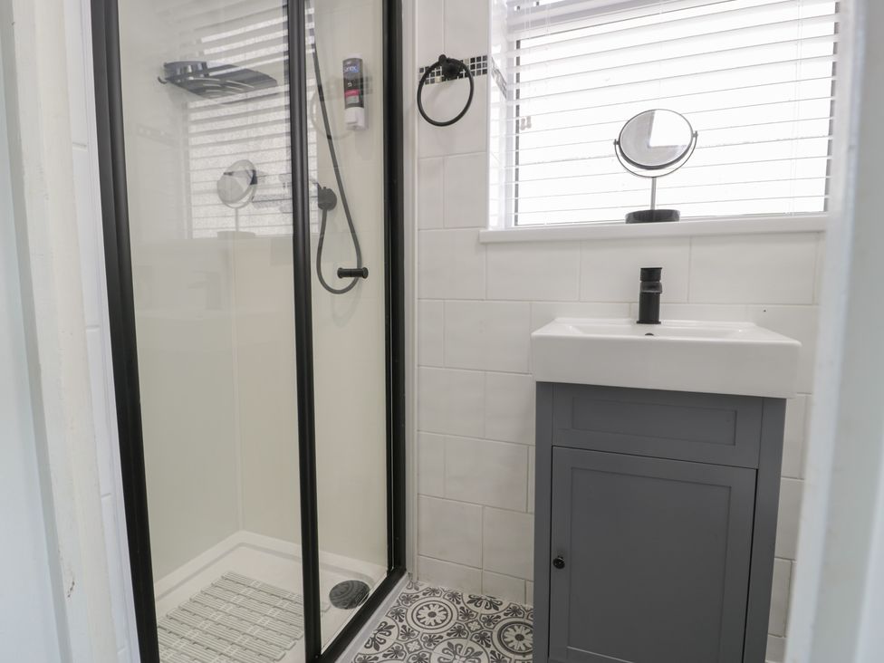 A bathroom with a shower and sink at 4 Haven Villas in Conwy