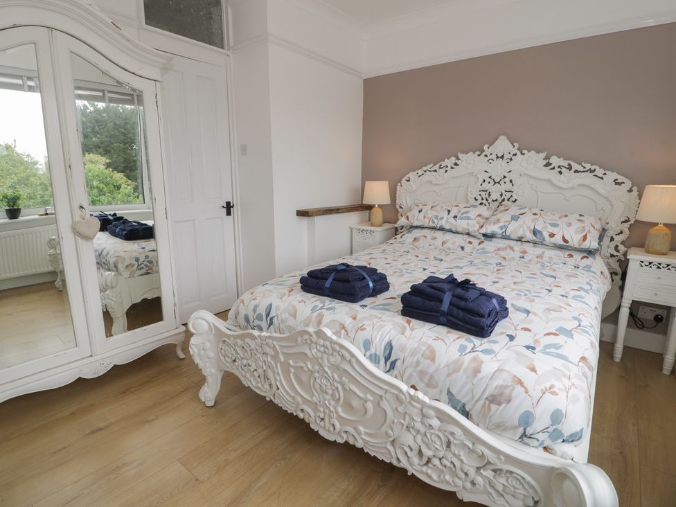 A bedroom with a bed and wardrobe at 4 Haven Villas, Conwy