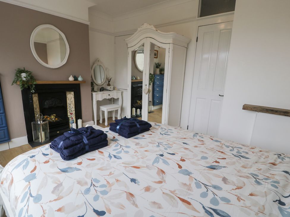 A bedroom with a bed and a mirror at 4 Haven Villas Conwy