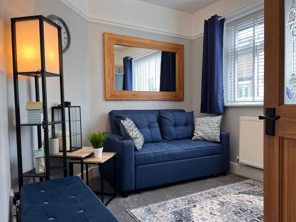 A living room with a sofa and lamp at Mid Haven Cottage in Conwy