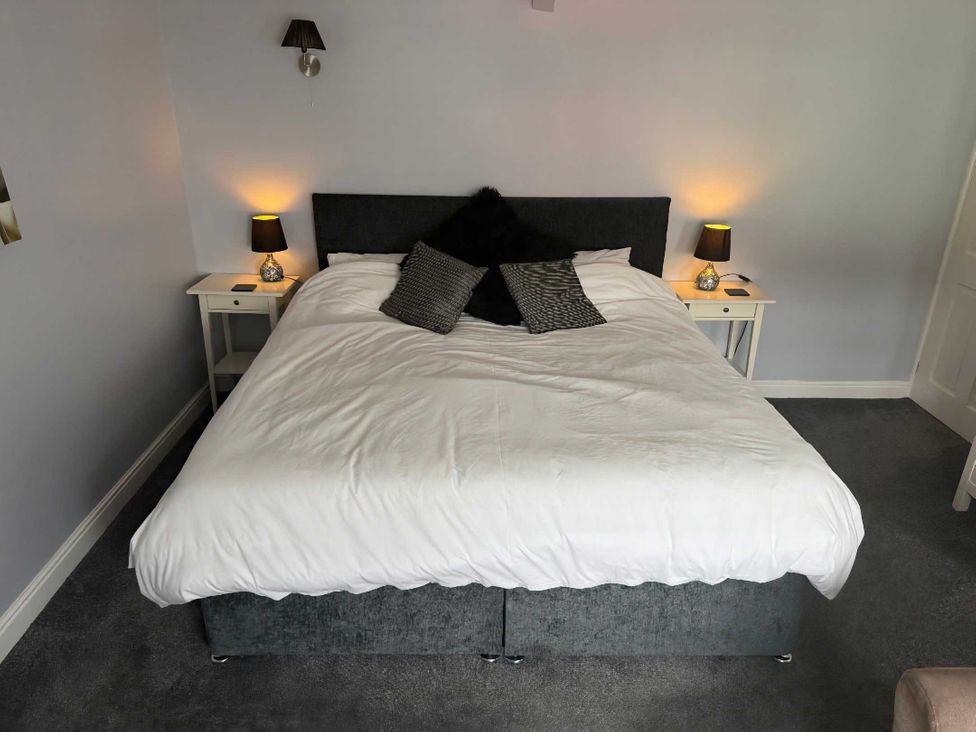 A bedroom with a bed and bedside tables at Triangle Inn Coachouse Rhayader