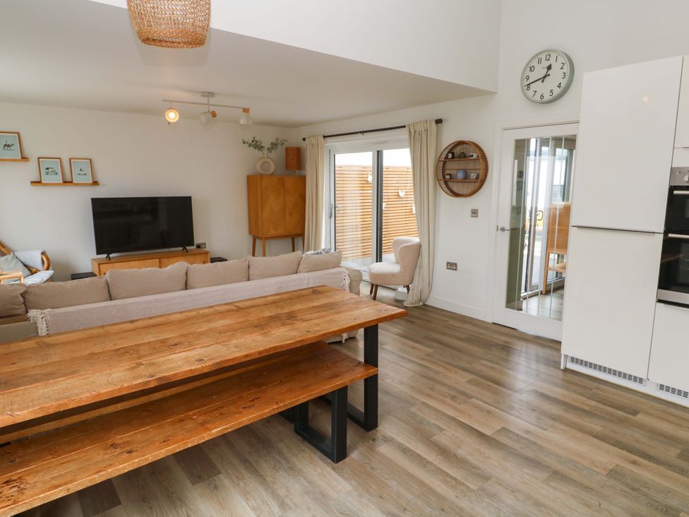 A living room with a television, sofa, and dining table at 6 Chapel Rock Close Perranporth