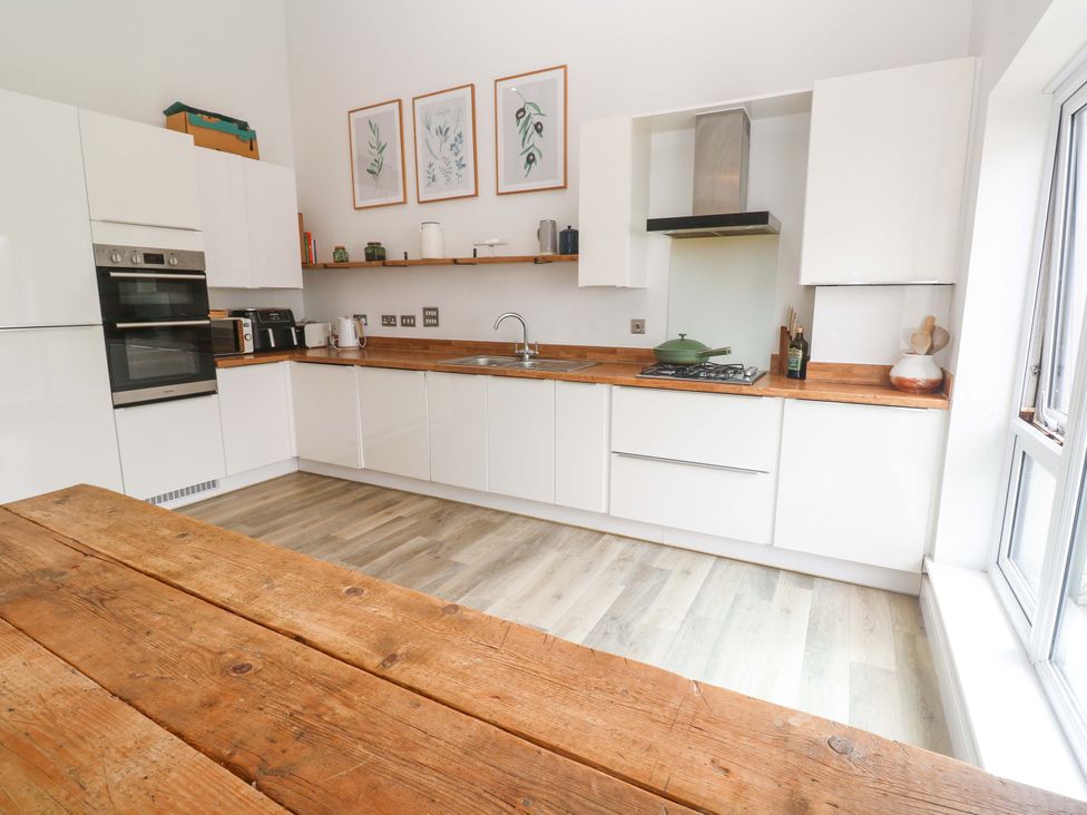 A kitchen with cabinets, stove, sink and a wooden table at 6 Chapel Rock Close Perranporth
