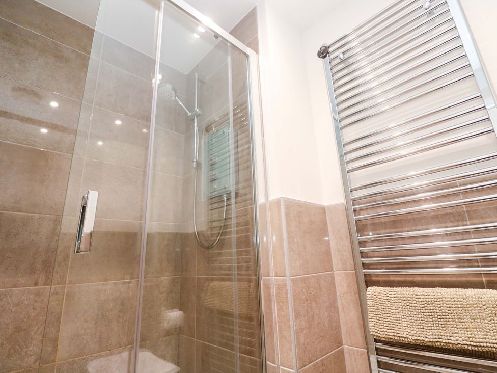 A shower with glass door and towel rail at 6 Chapel Rock Close Perranporth