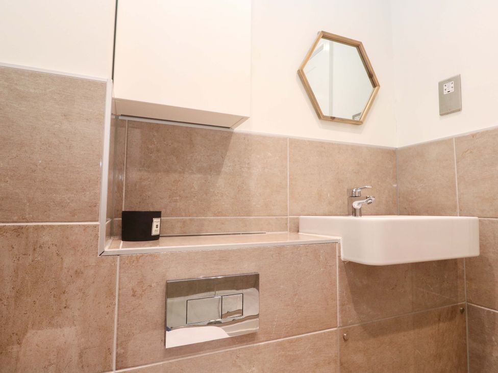 A bathroom with a sink and mirror at 6 Chapel Rock Close in Perranporth