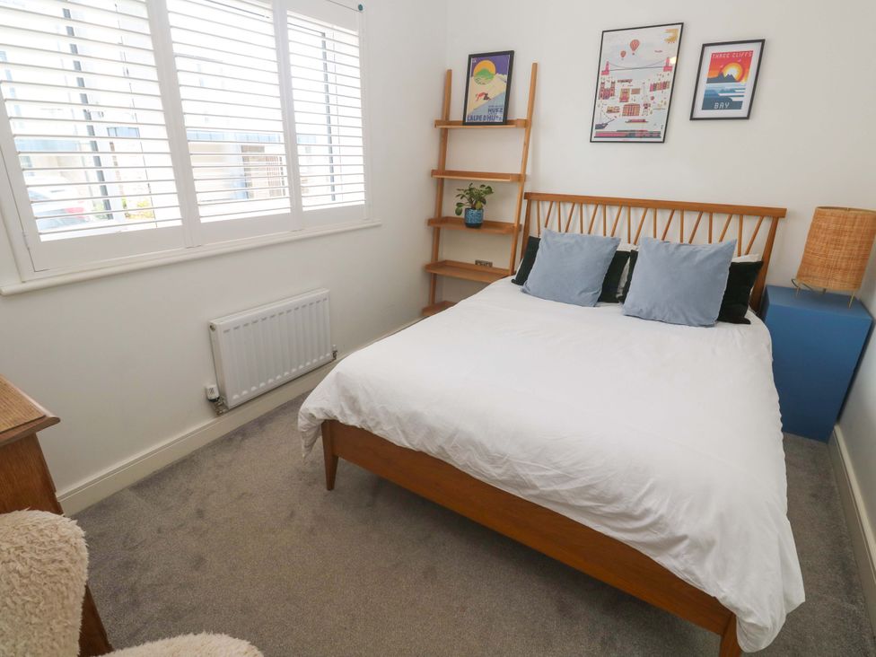 A bedroom with a bed and artwork on the walls at 6 Chapel Rock Close in Perranporth