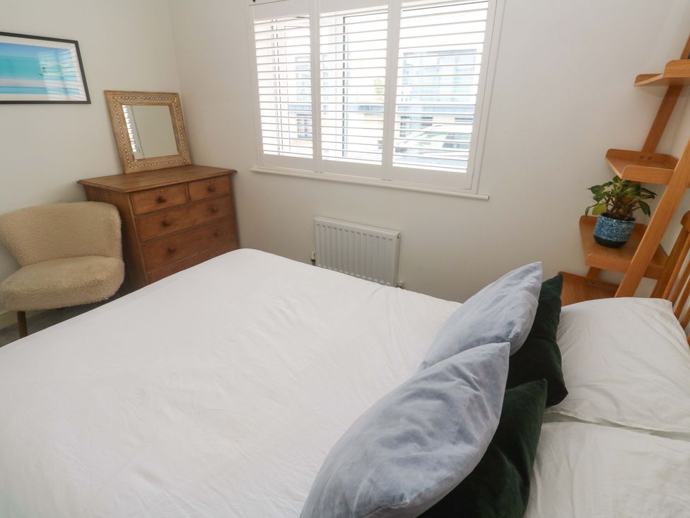 A bedroom with a bed, chest of drawers, and a plant at 6 Chapel Rock Close, Perranporth