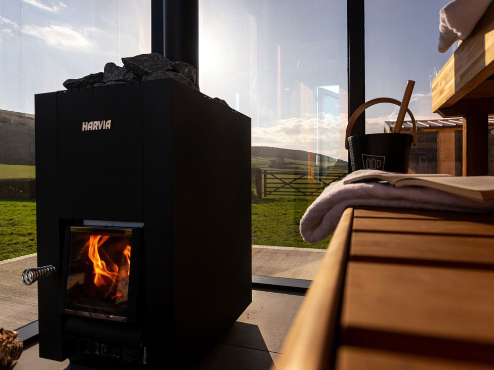 A sauna with a wood-burning stove and a bucket at Little Heaning in Cartmel