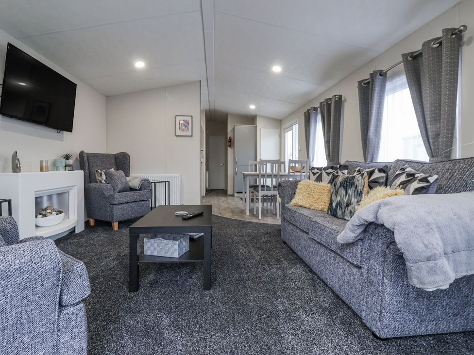 A living room with sofa and armchair at Lazy Daze in Carnaby near Bridlington