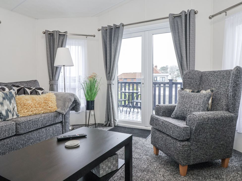 A living room with a sofa and armchair at Lazy Daze in Carnaby near Bridlington