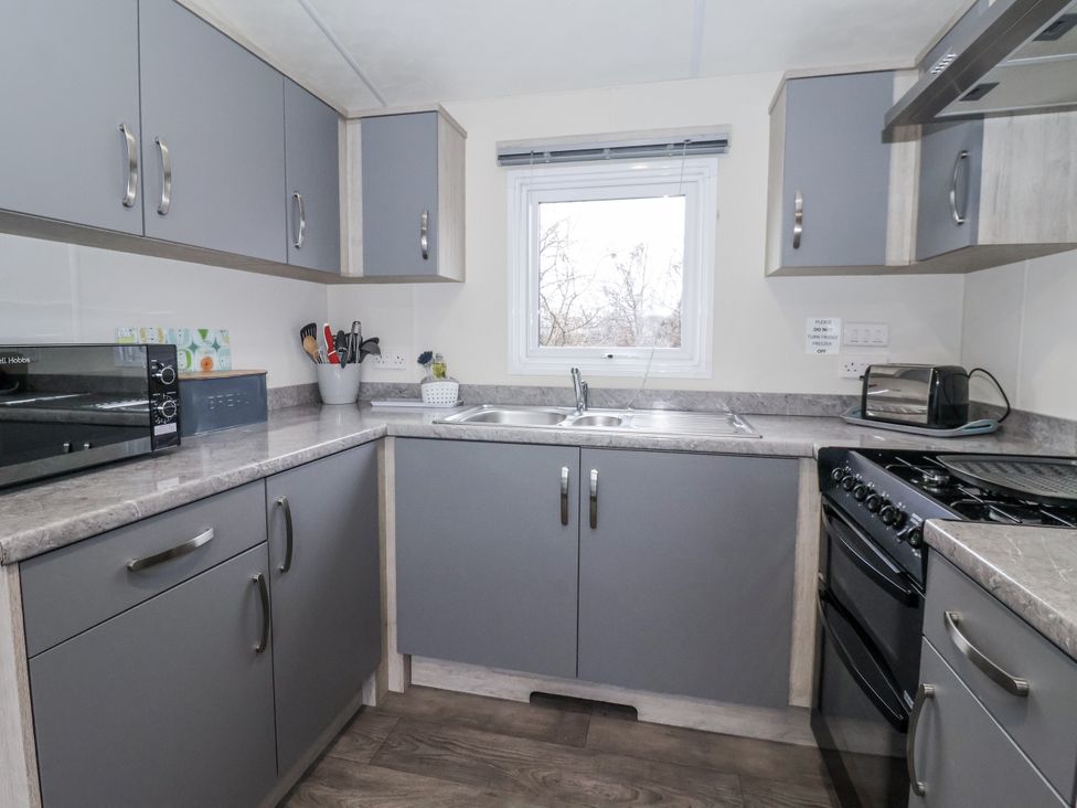 A kitchen with cabinets and appliances at Lazy Daze in Carnaby near Bridlington