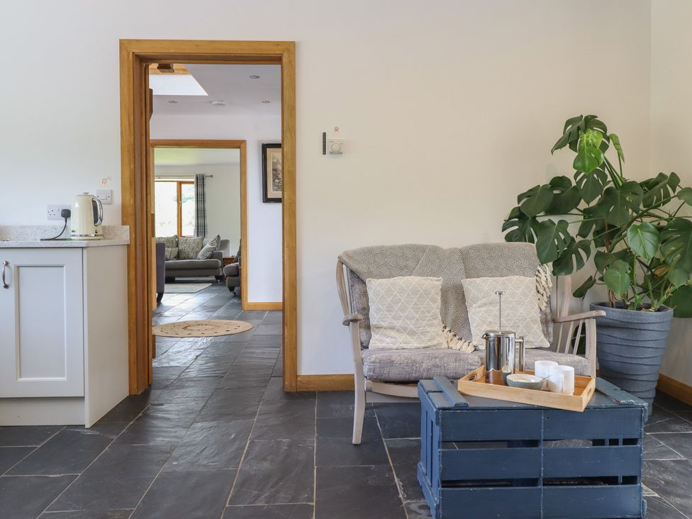 A living room with a coffee table and armchair at Cwmwr in Penybontfawr