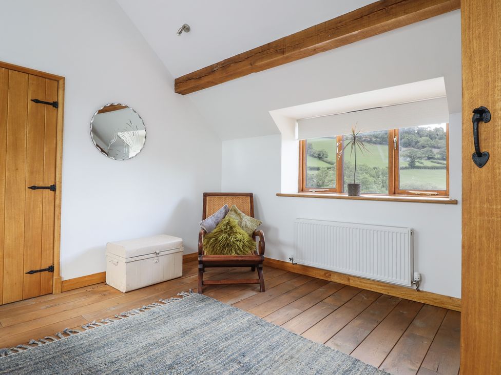 A snug with a chair and window at Cwmwr in Penybontfawr