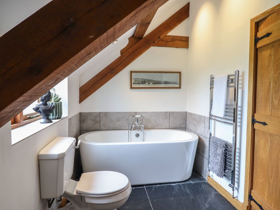 A bathroom with a bathtub and toilet at Cwmwr in Penybontfawr