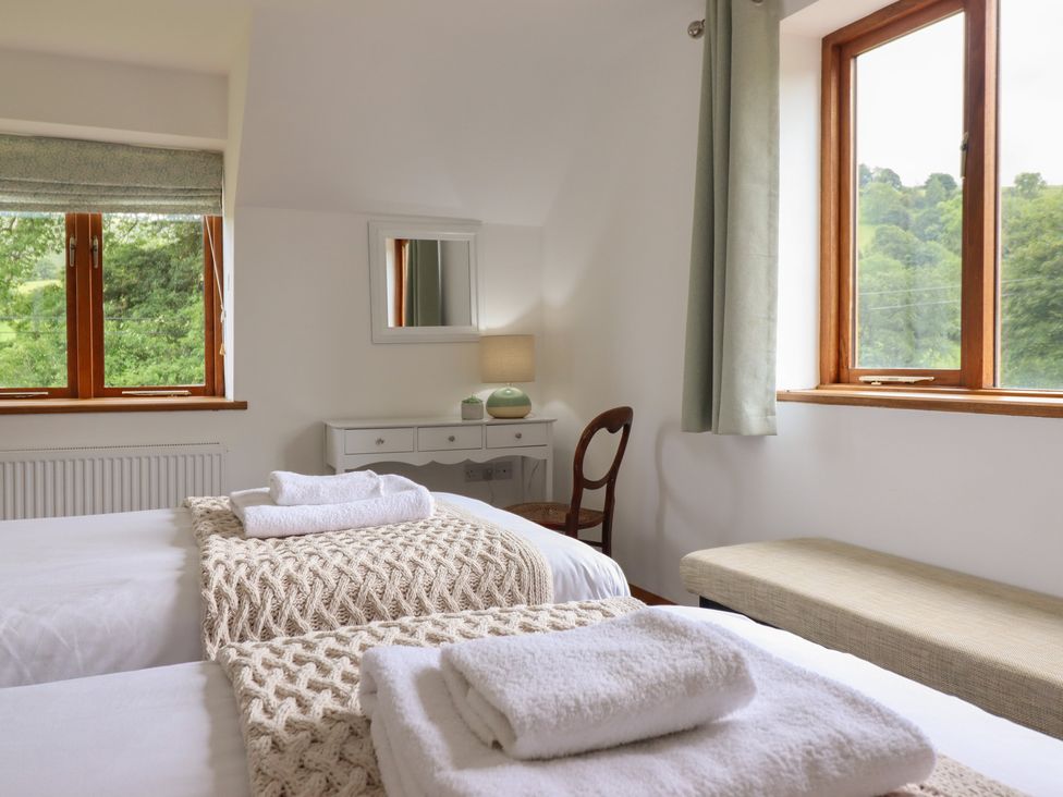 A bedroom with twin beds and a vanity table at Cwmwr in Penybontfawr