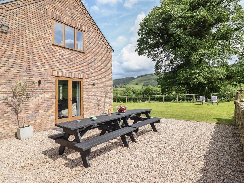 An outdoor area with a table and seating at Cwmwr in Penybontfawr