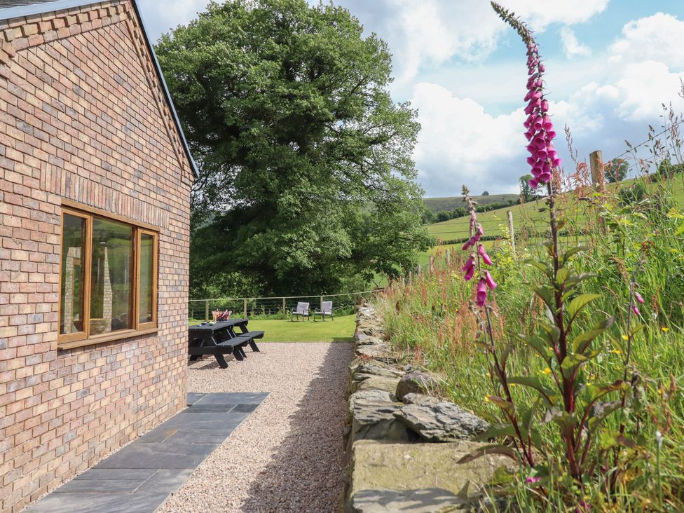 An outdoor area with a garden and seating at Cwmwr in Penybontfawr