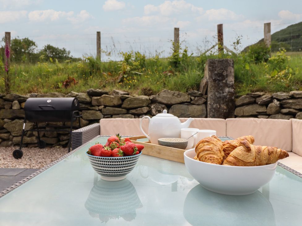 An outdoor table with croissants and strawberries at Cwmwr Penybontfawr