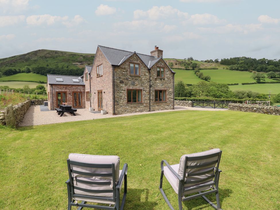 A house with a garden and chairs at Cwmwr Penybontfawr