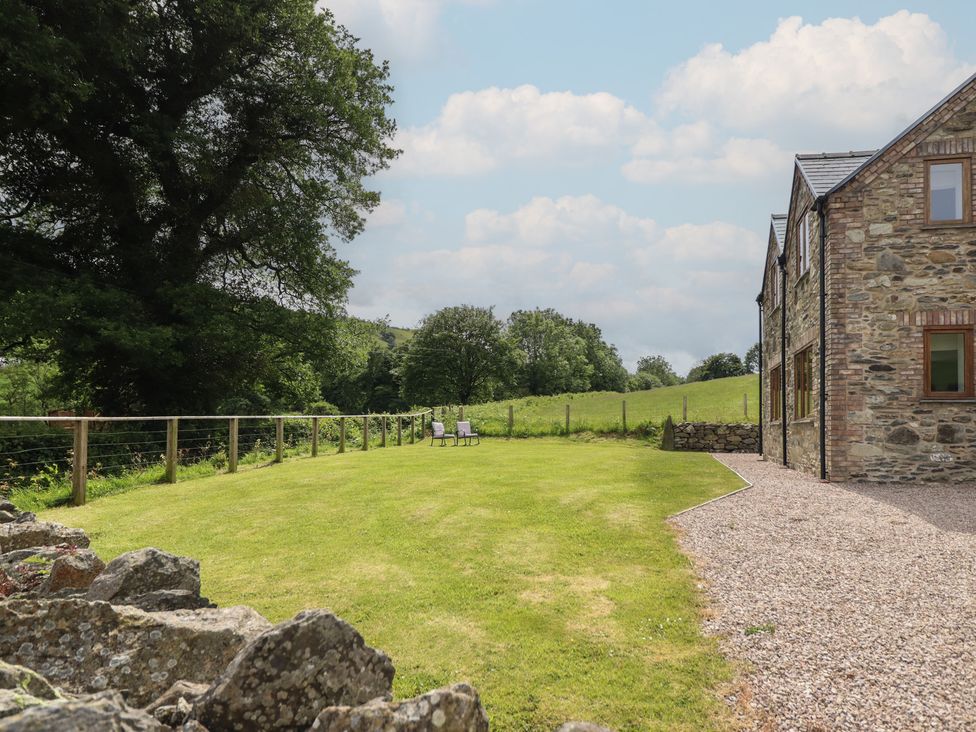 An outdoor area with lawn, fence, and chairs at Cwmwr Penybontfawr
