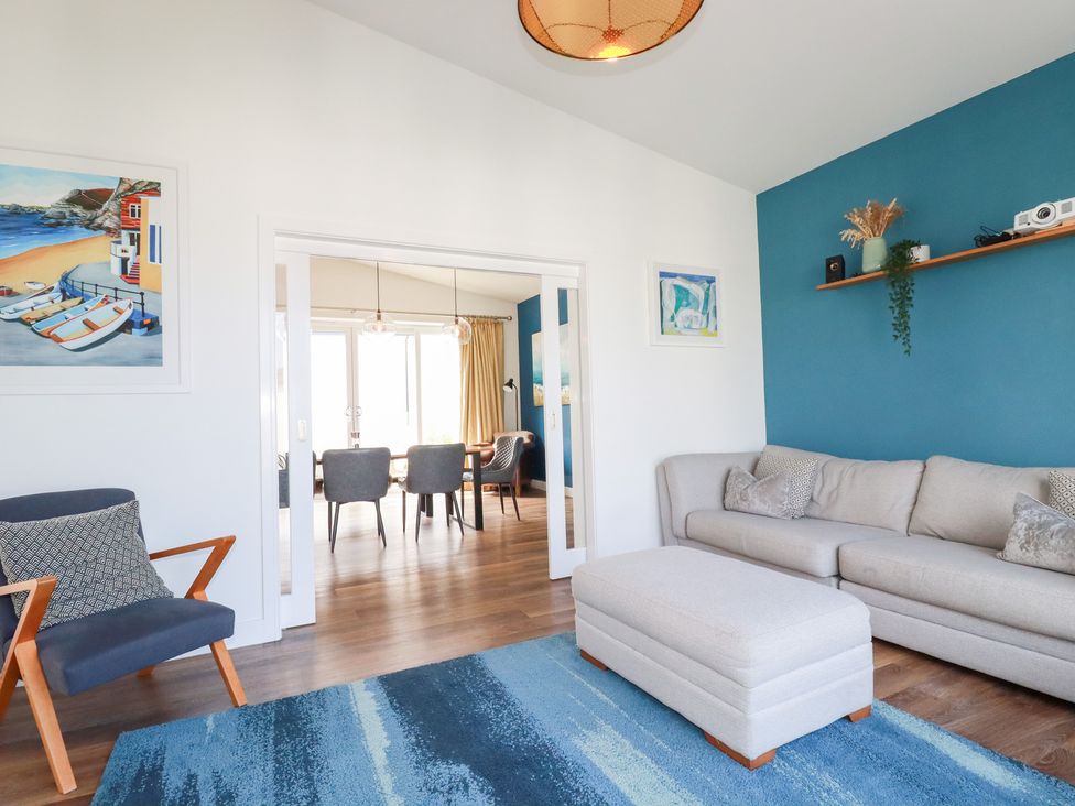 A living room with a sofa and artwork at Beach Haven in Perranporth