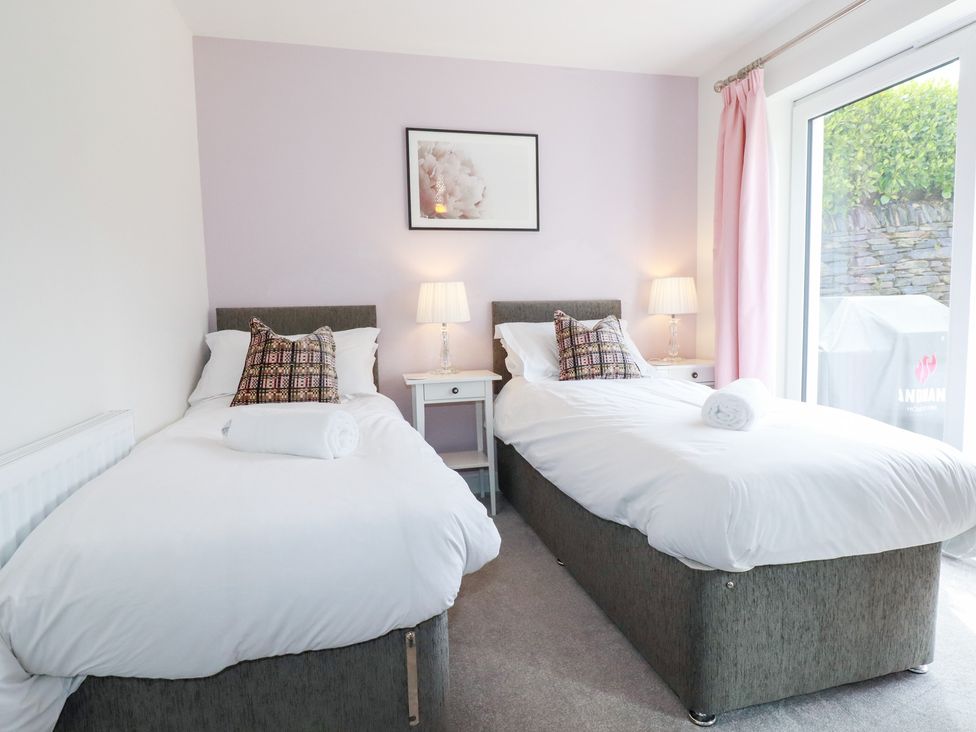 A bedroom with twin beds and a bedside table at Beach Haven in Perranporth