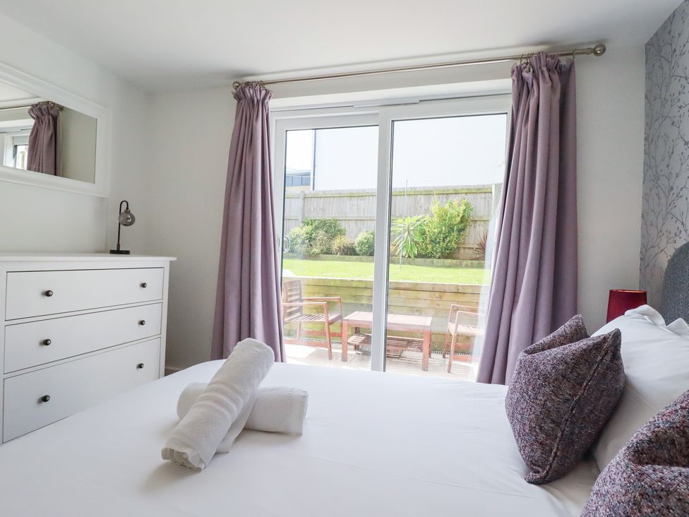 A bedroom with a bed and dresser at Beach Haven in Perranporth