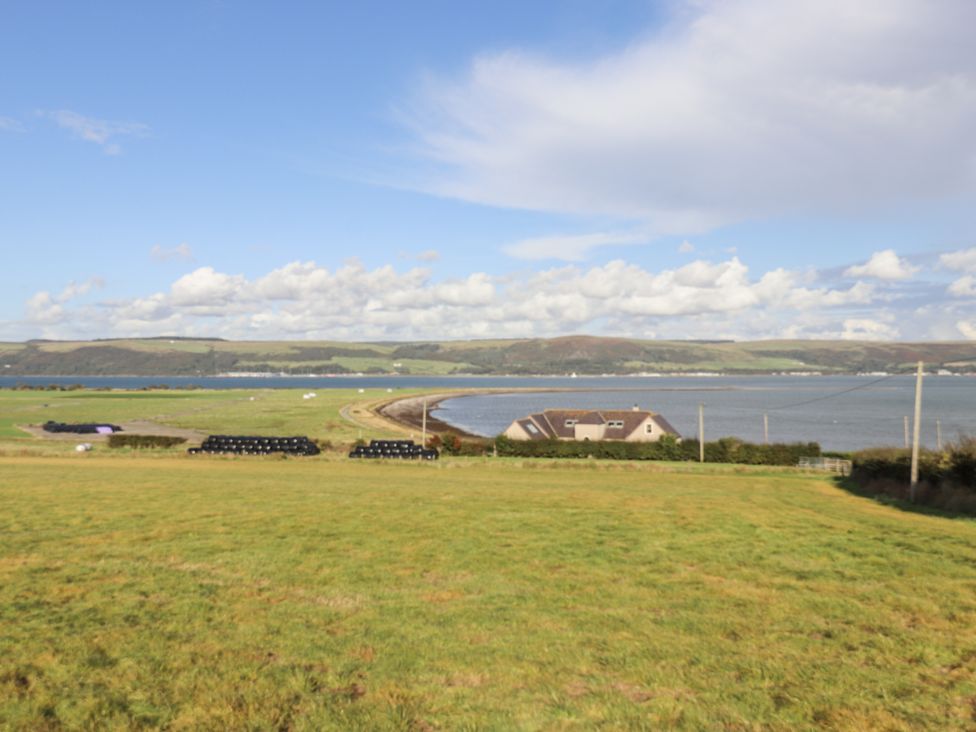 A coastal view with a house and water at Kringlands in Kirkcolm