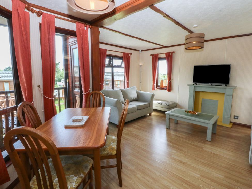 A living room with a table and chairs at 16 Forest Lodge in Chwilog