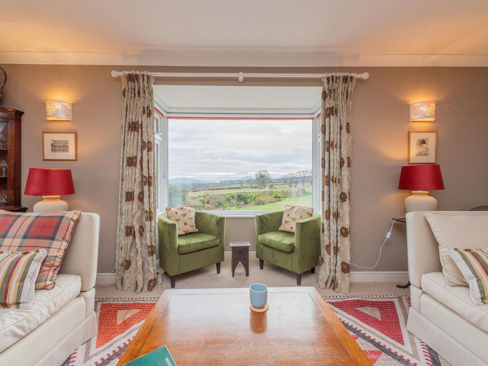 A living room with armchairs and a view at Pear Tree Cottage in Church Pulverbatch near Dorrington
