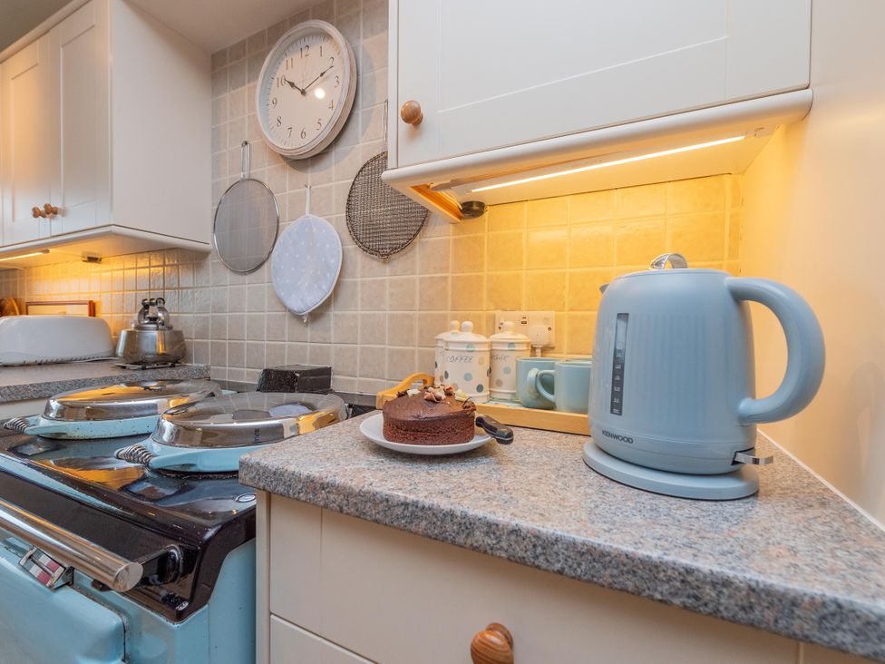 A kitchen with a cake and a kettle at Pear Tree Cottage near Church Pulverbatch