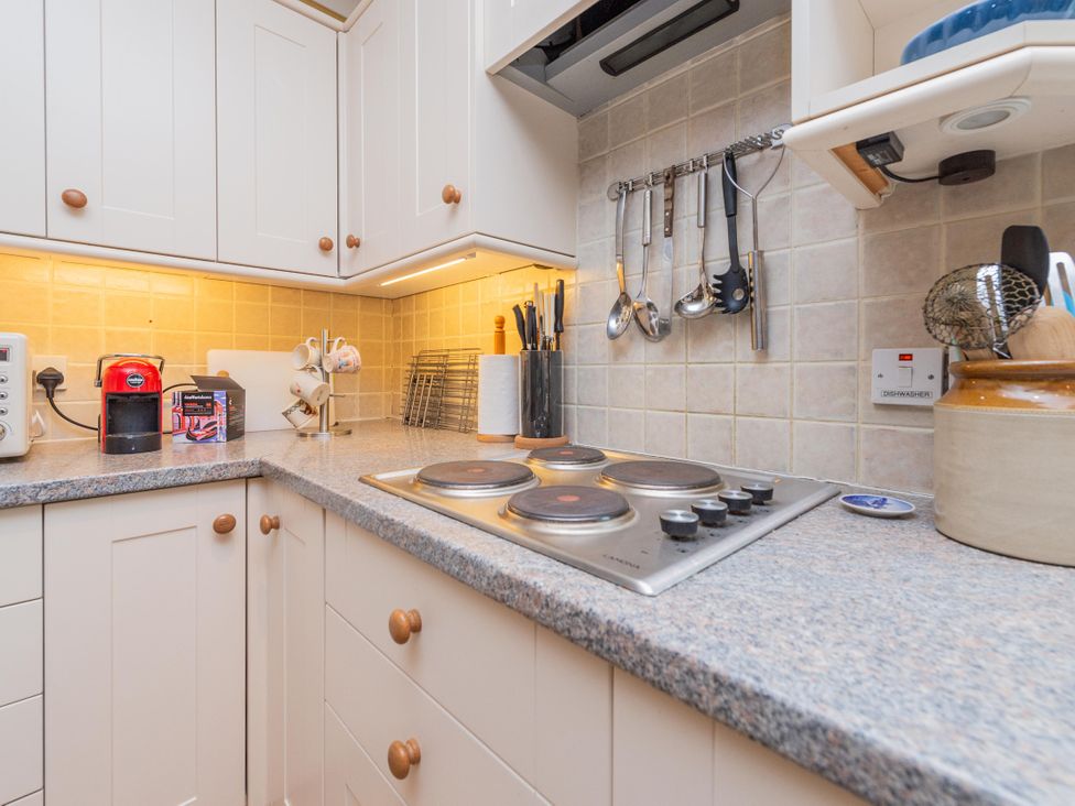 A kitchen with a stove, coffee maker, and utensils at Pear Tree Cottage Church Pulverbatch near Dorrington