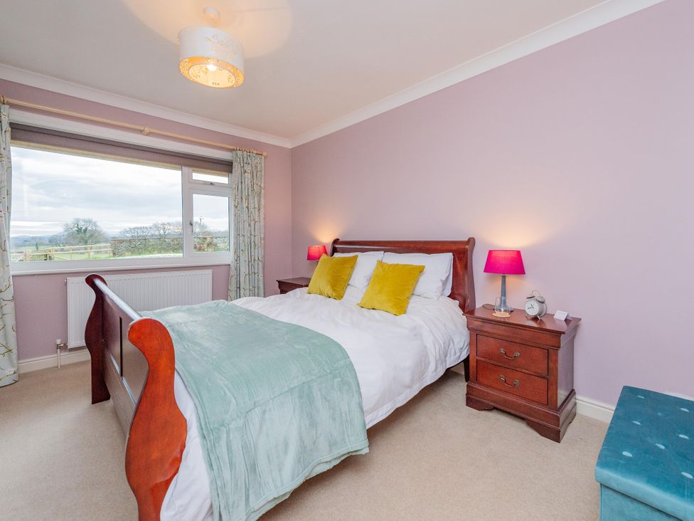 A bedroom with a bed and nightstand at Pear Tree Cottage in Church Pulverbatch near Dorrington