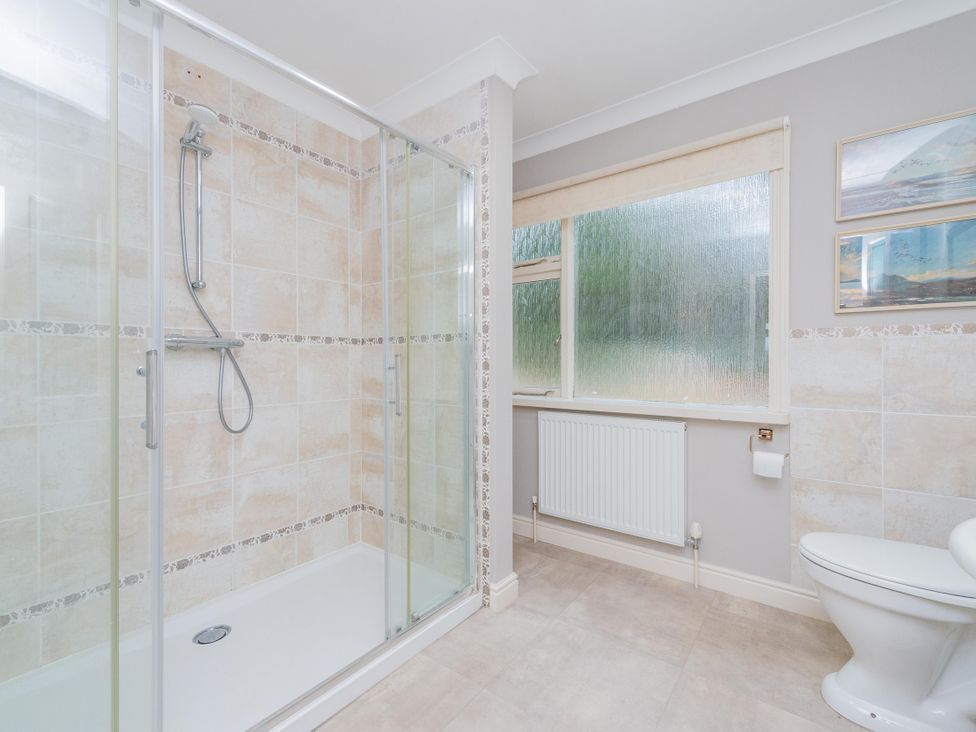A bathroom with a shower cubicle and toilet at Pear Tree Cottage in Church Pulverbatch near Dorrington