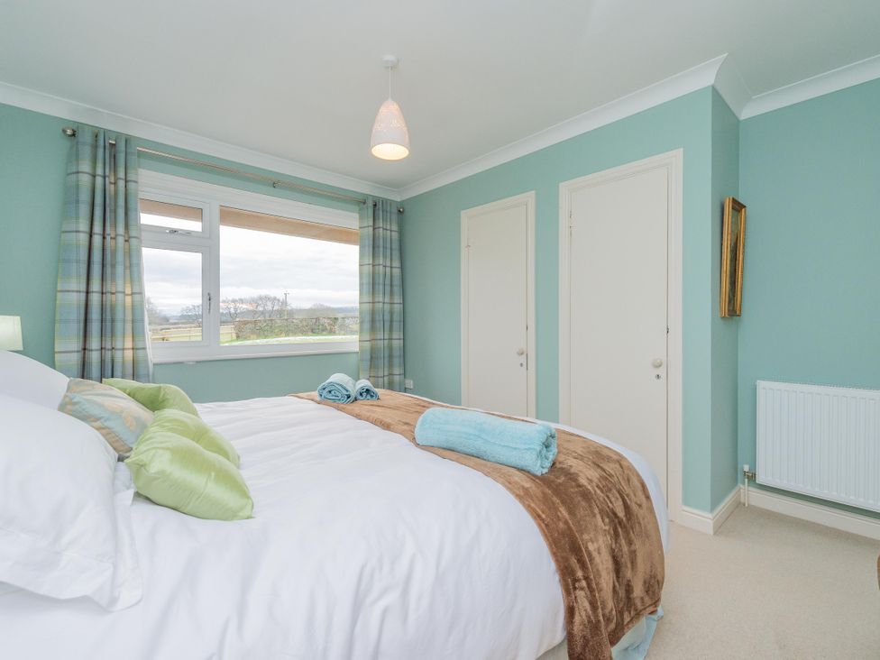 A bedroom with a bed and window at Pear Tree Cottage near Church Pulverbatch