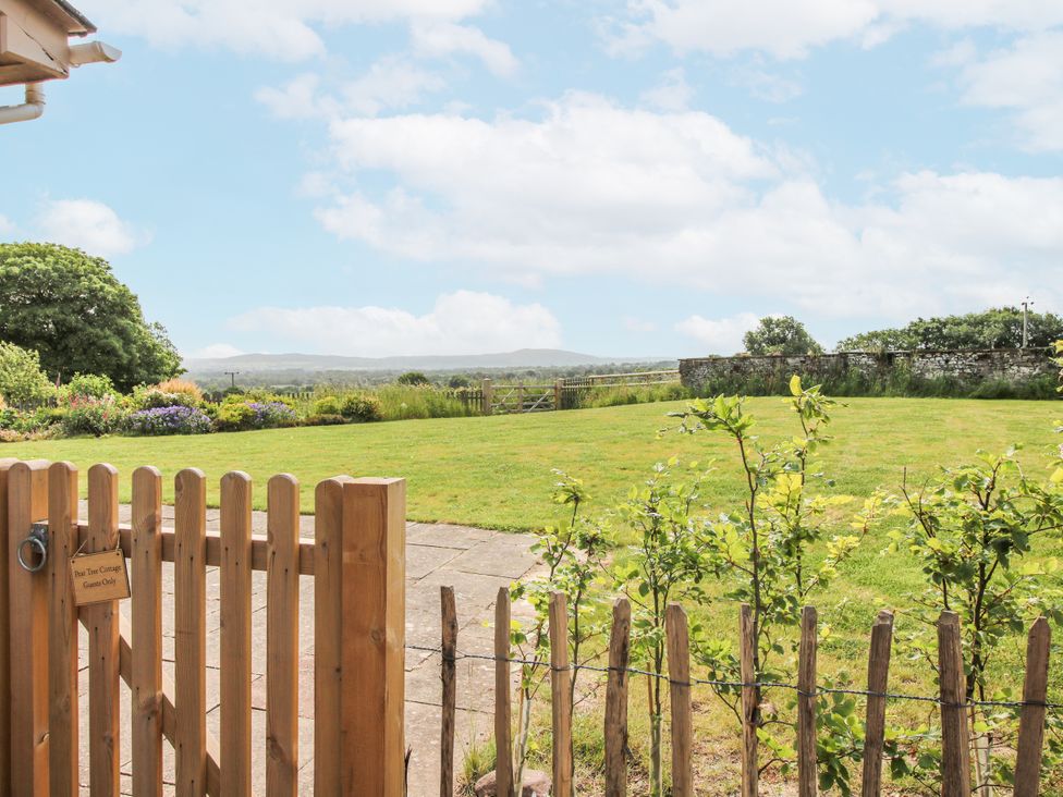 A garden with a gate and lawn at Pear Tree Cottage Church Pulverbatch near Dorrington