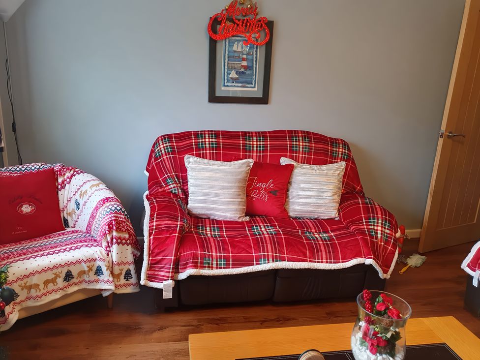 A living room with sofas and decorative cushion at Normandy in Nefyn