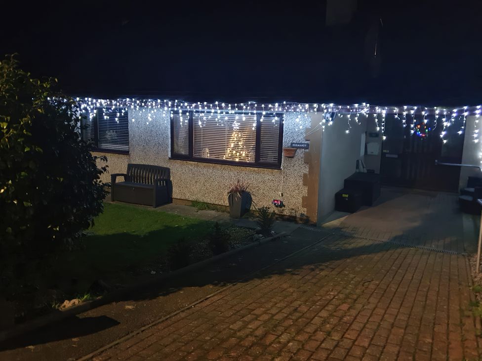 A house with decorative lights and a bench at Normandy in Nefyn