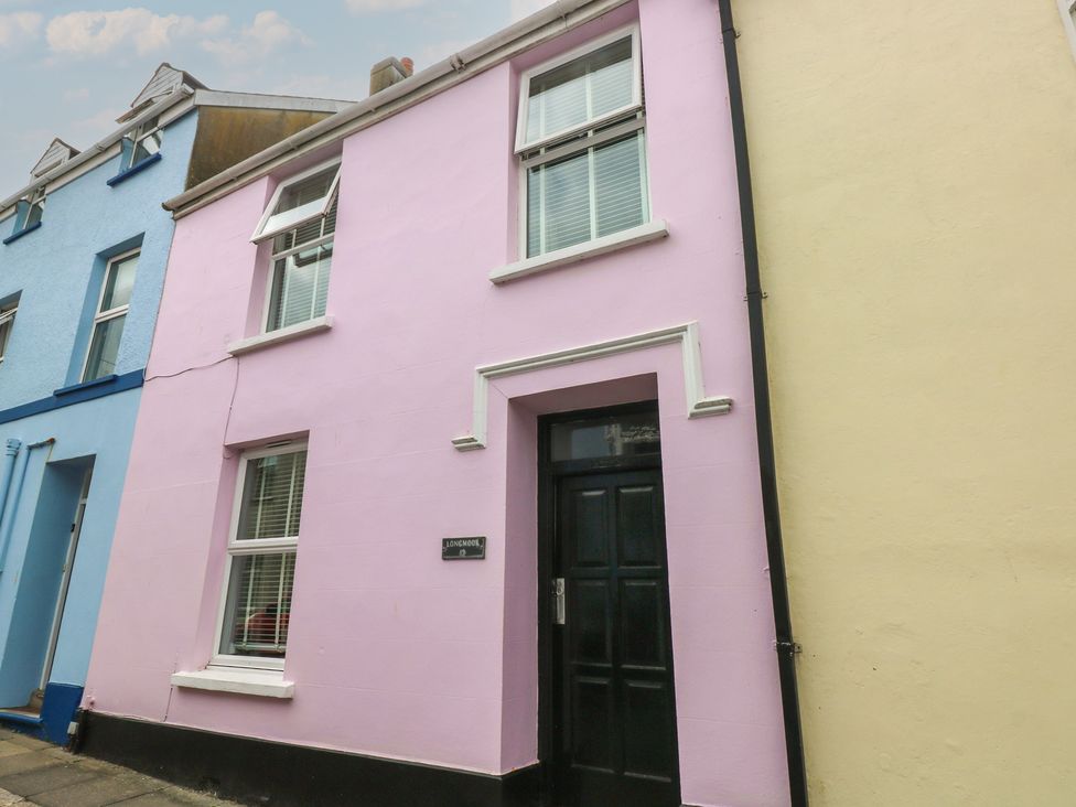 A pink building with a black door at Longmoor in Tenby