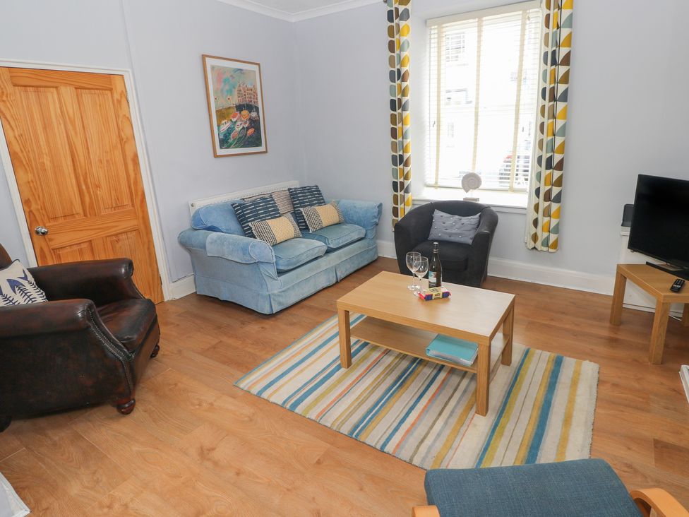 A living room with a sofa and armchair at Longmoor in Tenby