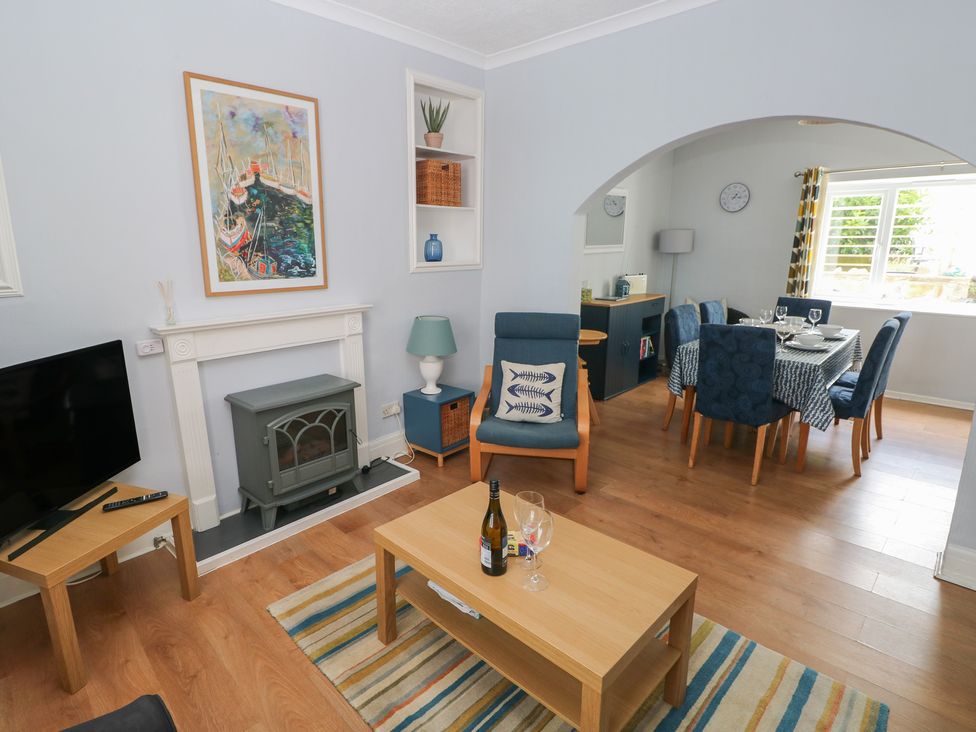 A living room with a television and coffee table at Longmoor in Tenby
