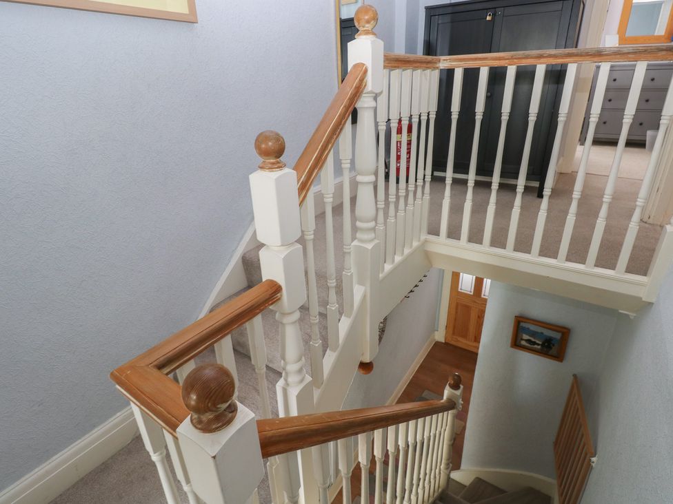 A staircase with a handrail in a hallway at Longmoor in Tenby