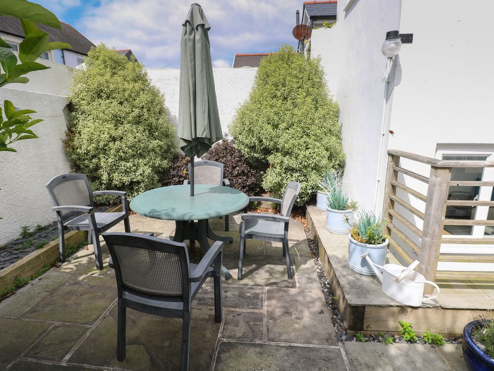 A garden area with a table and chairs at Longmoor in Tenby