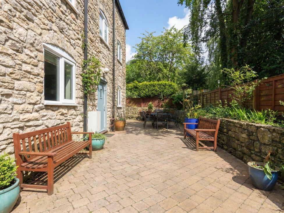 An outdoor area with stone walls and seating at The Grain Store in Weymouth