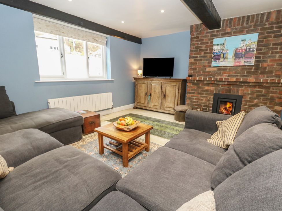 A living room with a sofa, coffee table, and television at The Grain Store in Weymouth