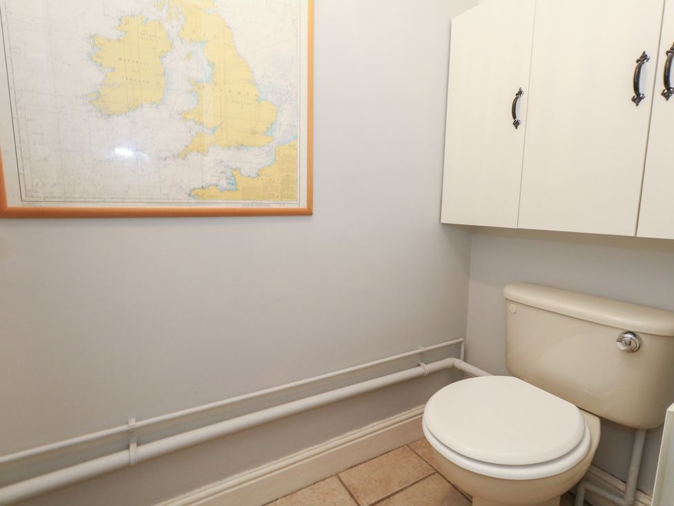 A bathroom with a toilet and storage cabinet at The Grain Store in Weymouth