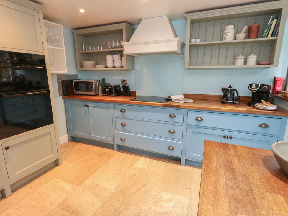 A kitchen with cabinets and appliances at The Grain Store in Weymouth